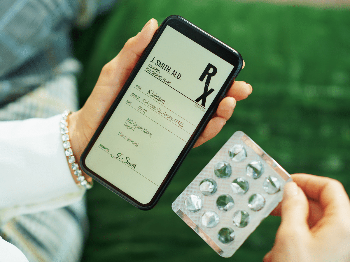 Leeres Tabletten-Blister neben einem Smartphone, das ein eRezept darstellen soll